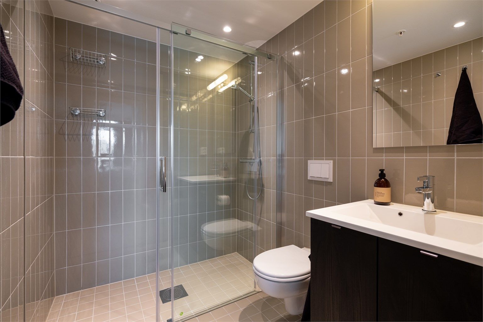 Pent, flislagt baderom med varme i gulv og downlights i himling.