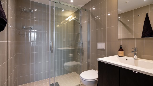 Pent, flislagt baderom med varme i gulv og downlights i himling.