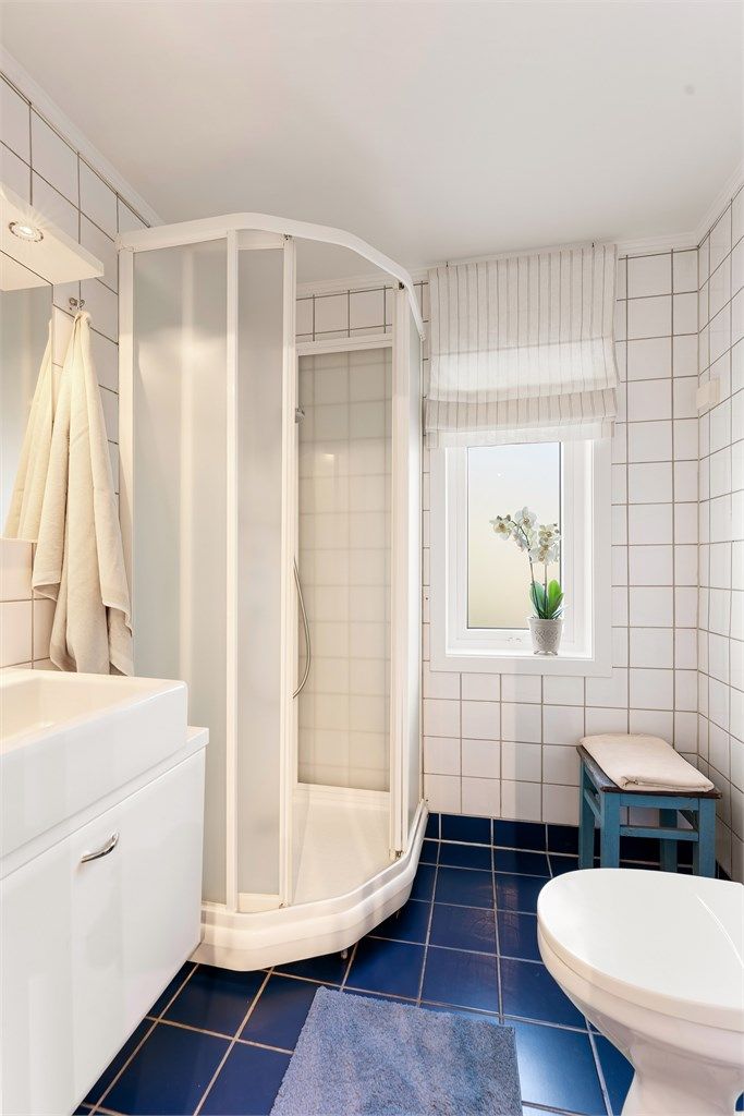 Badet er utstyrt med dusjkabinett, toalett og vindu for dagslys.