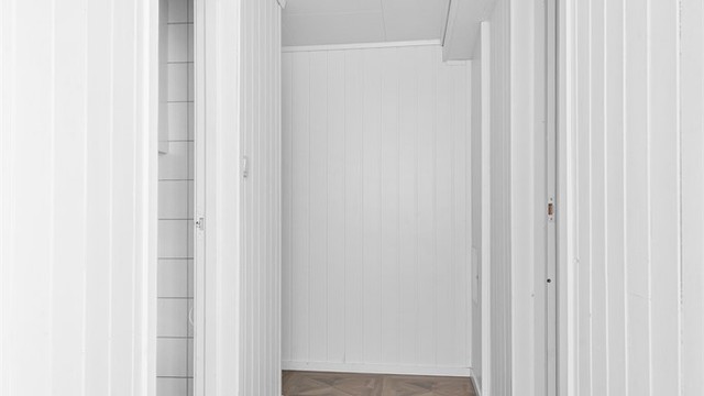Gang i underetasjen med panel på veggene.