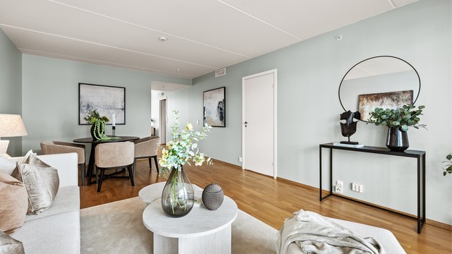 Stue med sofaområde og spiseplass. Delåpen løsning mot kjøkkenet.