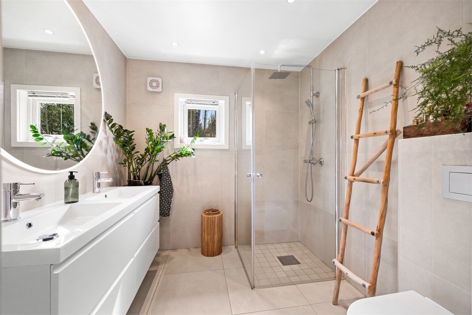 Det delikate badet har et dusjhjørnet med glassdører og regnfallsdusj.
