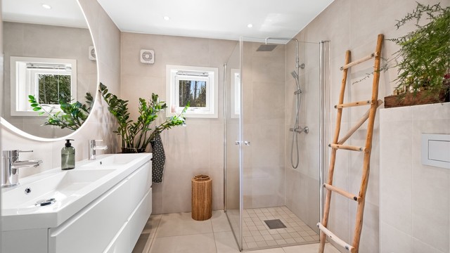Det delikate badet har et dusjhjørnet med glassdører og regnfallsdusj.