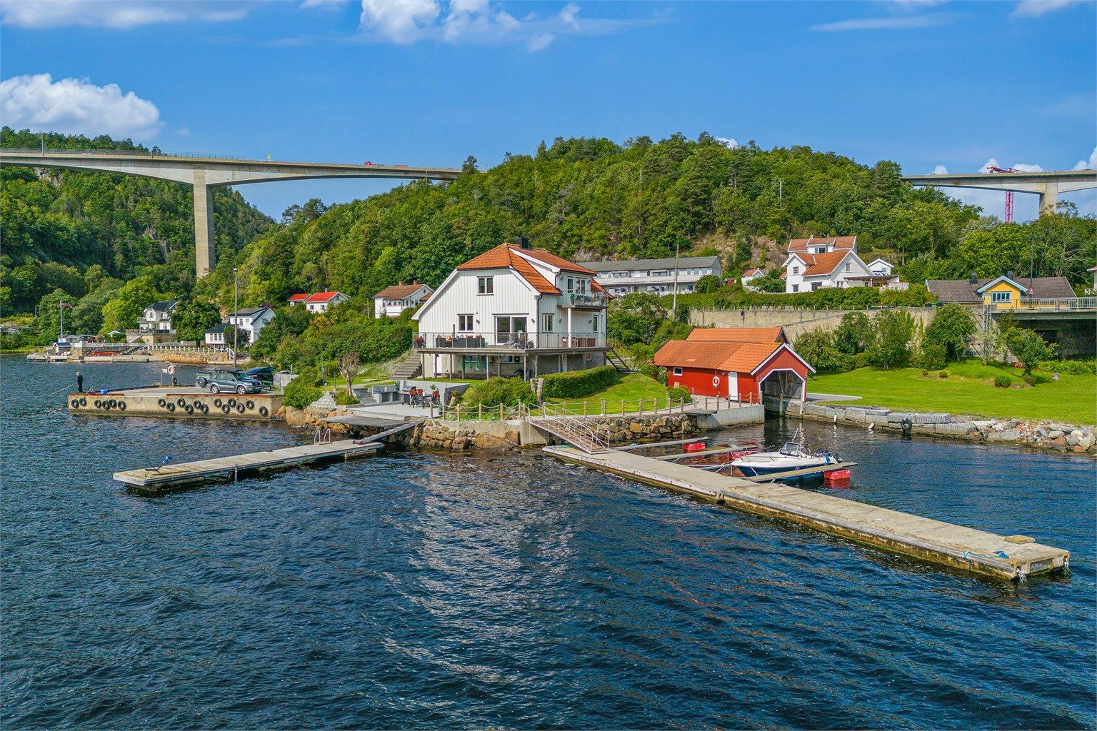 Lang strandlinje, egen brygge, båthus, garasje, terrasser, uteplasser og en stor gresslette er noe av det vi finner i Langangsveien 233.