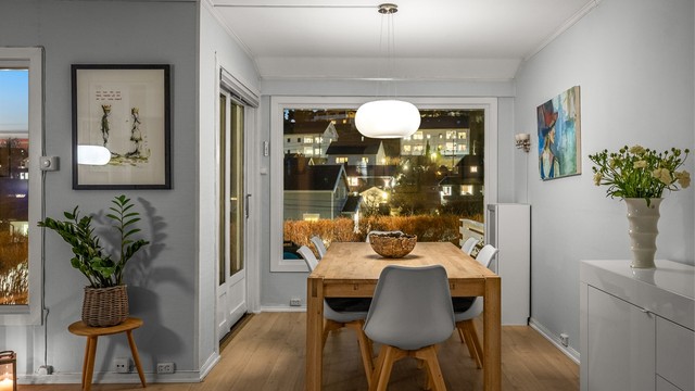 Spisestuen med utsikt mot nabolaget på kveldstid.