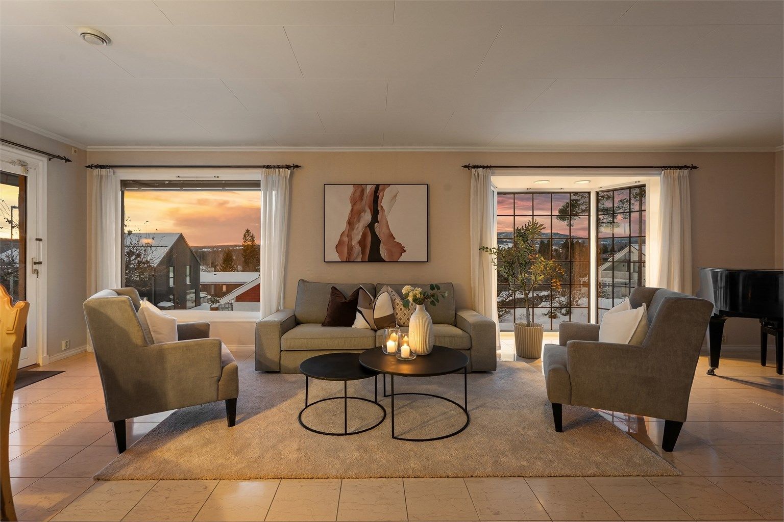 Stuen er romslig med flislagt gulv og store vindusflater som gir godt med lys.