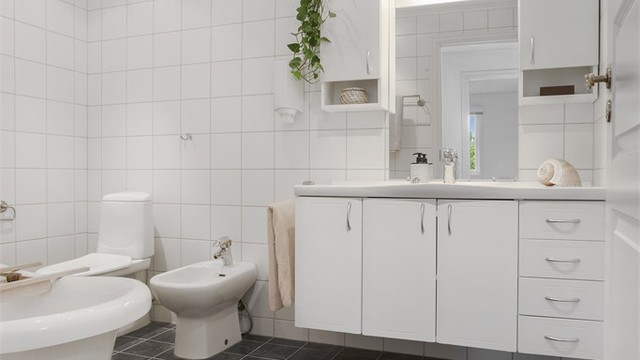 Flislagt bad i 1. etasje med varmekabler, badekar, bidé og servantskap.