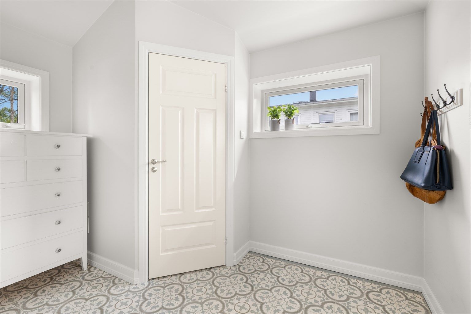 Entré med håndlagde Ulfven-gulvfliser med gulvvarme og god plass til oppbevaring. Ytterdør med kodelås fra Yale Doorman. I praktisk tilknytning til entréen ligger toalettet