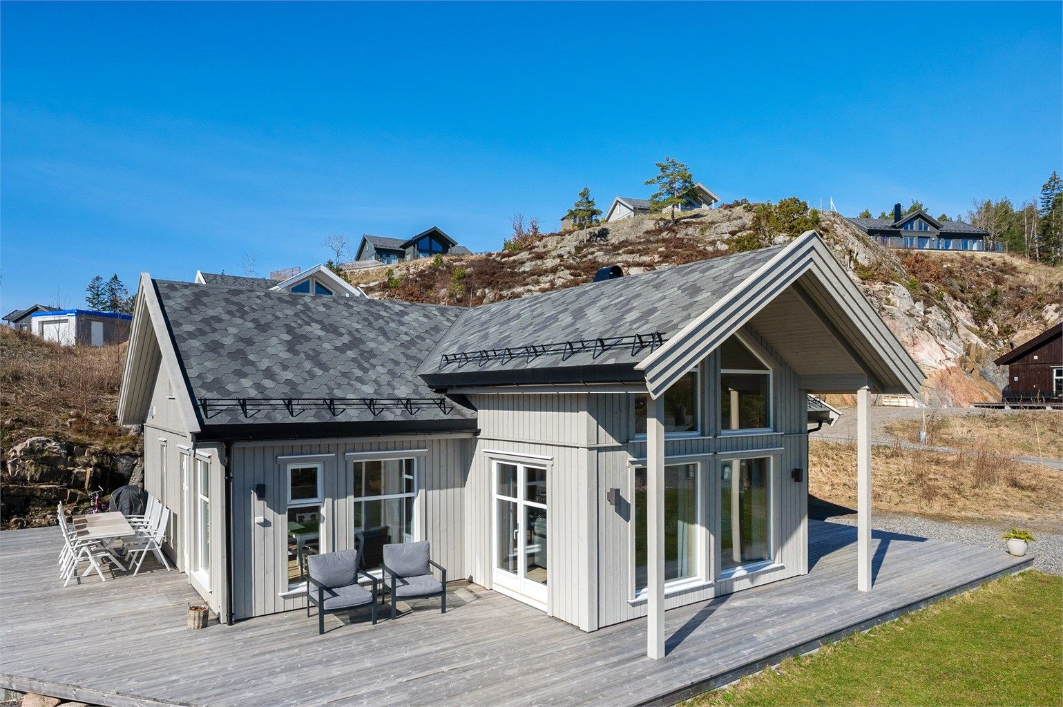 Eiendommen har en romslig tomt opparbeidet med plen, terrasse og gruset innkjørsel hvor det er gode parkeringsmuligheter