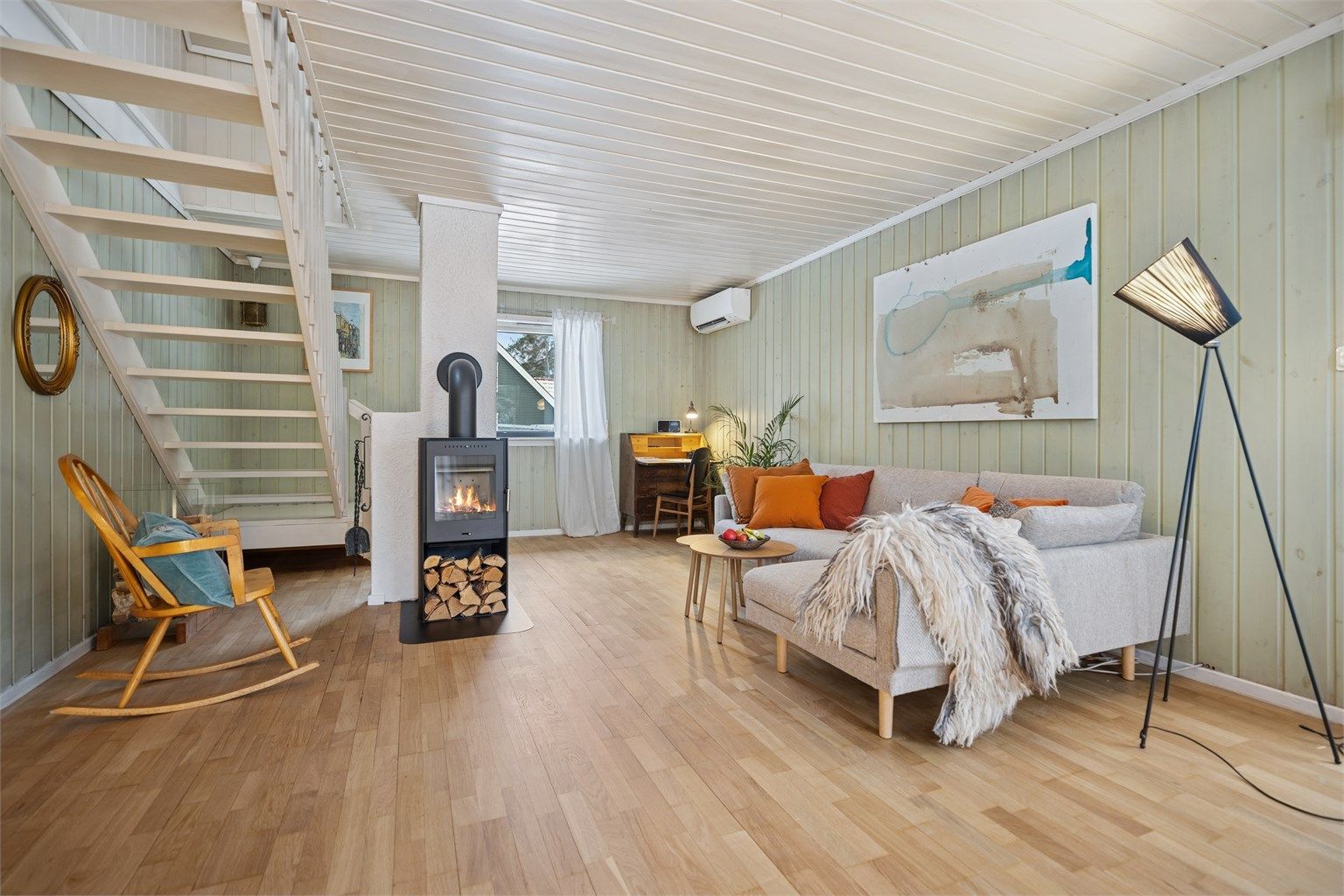 Hyggelig stue med parkettgulv og vedovn, som skaper en lun og behagelig atmosfære, i tillegg er det montert varmepumpe. 