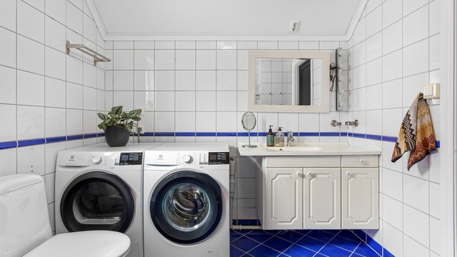Badet i første etasje har flislagt gulv med gulvvarme og opplegg for vaskemaskin samt tørketrommel.