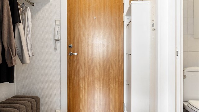 Entré med parkett på gulv og malte vegger. Her er det et plassbygget skap samt nisje med plass til oppheng av yttertøy og sko.