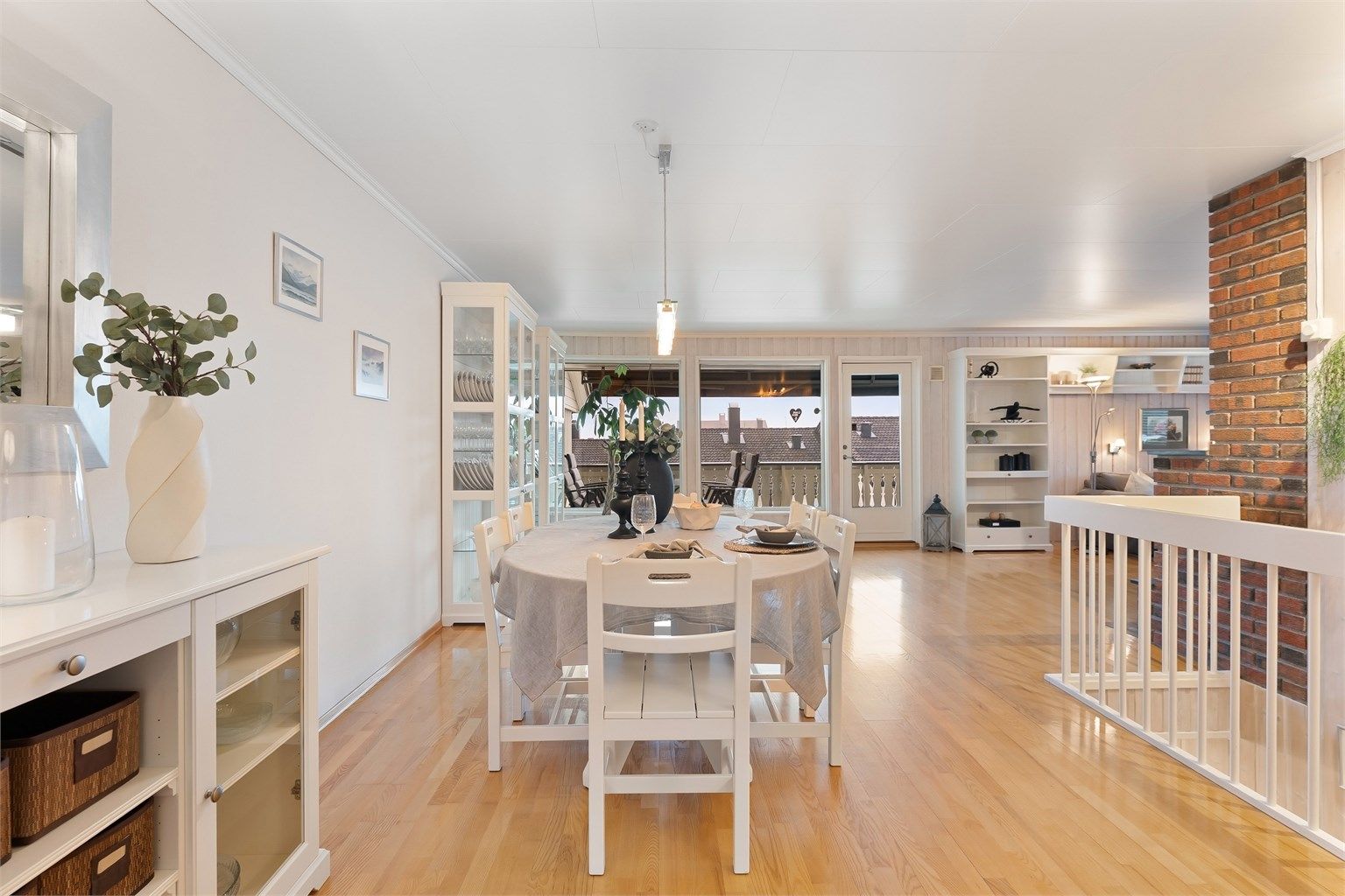 Den romslige stuen og spisestuen har gjennomgående parkettgulv og utgang til en stor veranda.