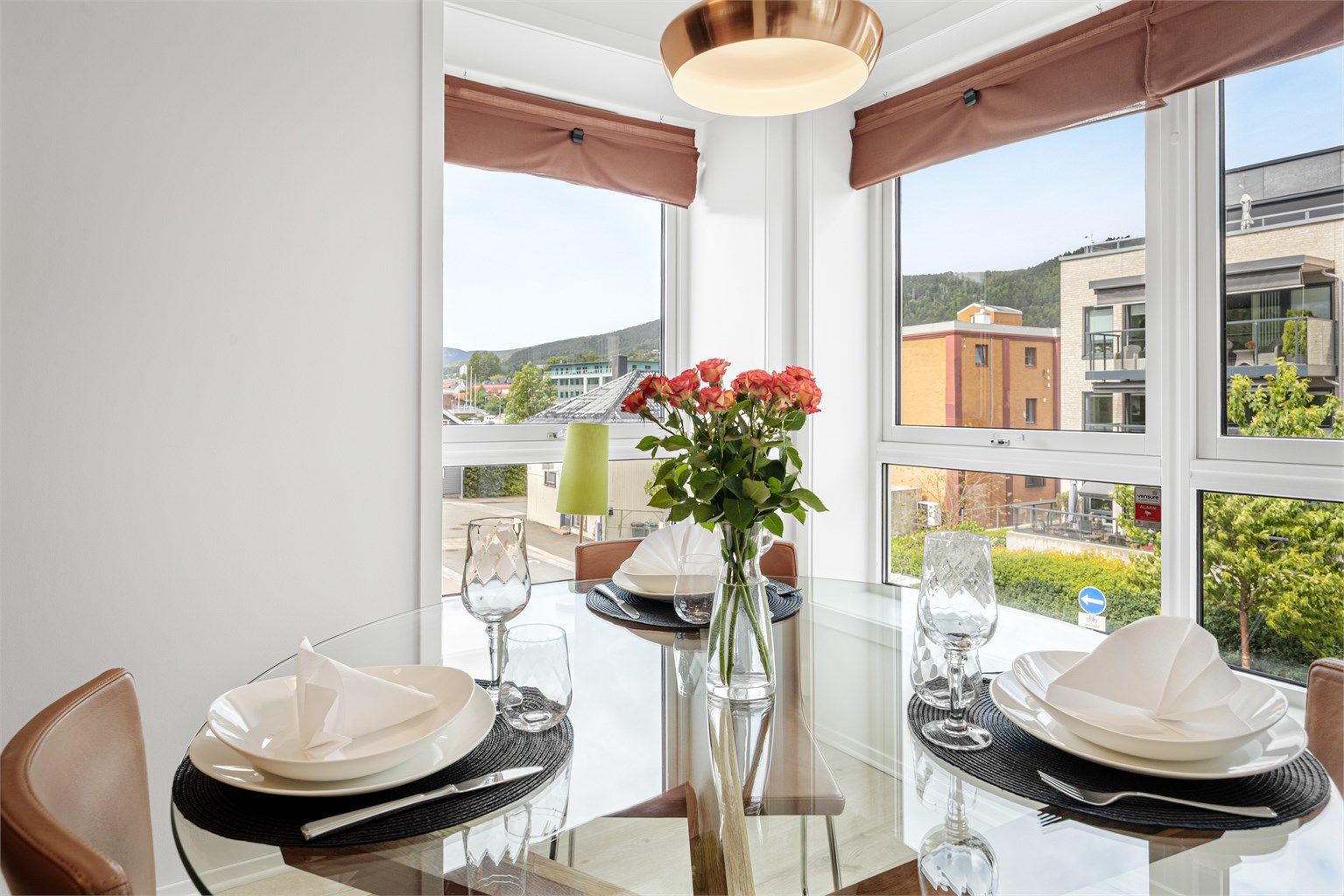 Spiseplass i enden av rommet med store vest- og nordvendte vinduer. 