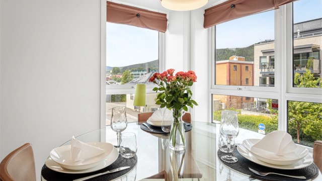 Spiseplass i enden av rommet med store vest- og nordvendte vinduer.