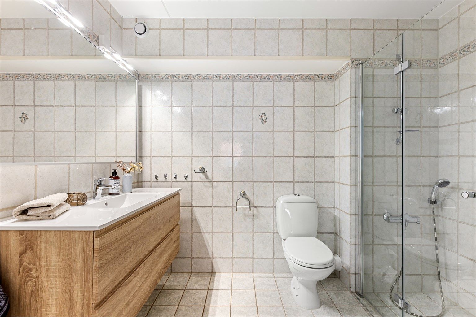 Badet er fra byggeår, med oppgradert innredning og dusjvegger fra 2021. 