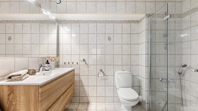 Badet er fra byggeår, med oppgradert innredning og dusjvegger fra 2021.