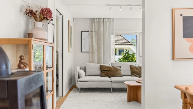 Stuen ligger delvis skjermet fra spiseplassen og oppleves som en lun og komfortabel oppholdssone.
