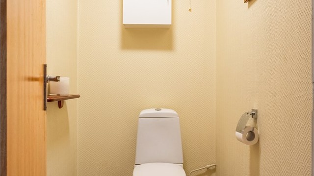 Separat toalettrom i andre etasje med fliser på gulv og gulvstående toalett.