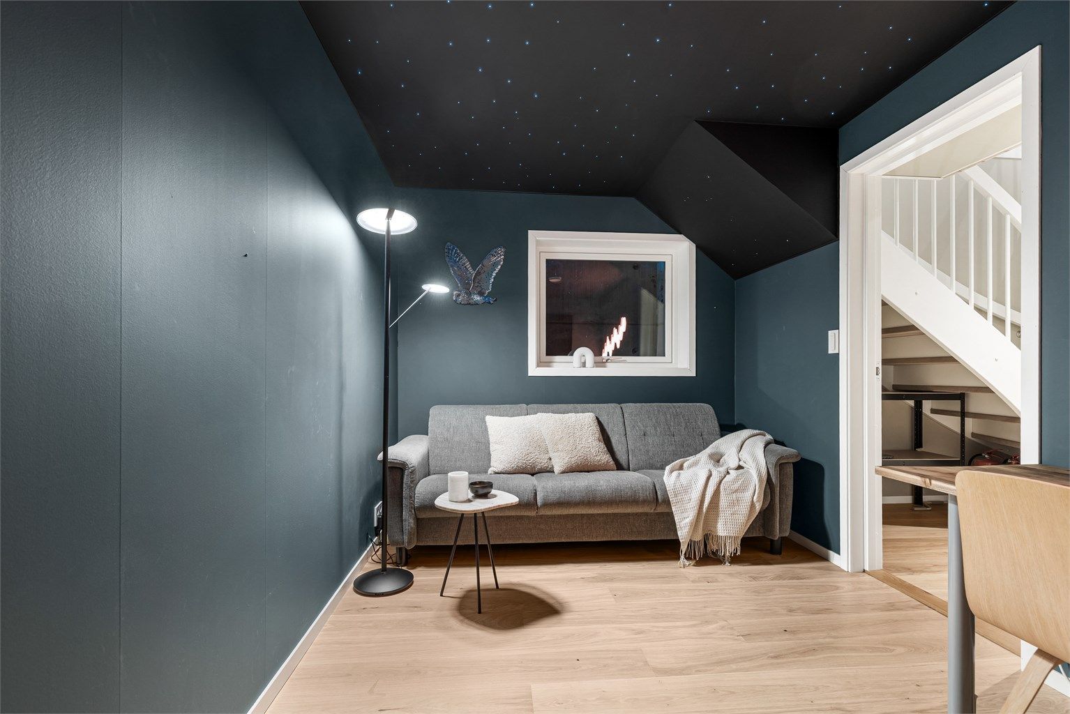 Stilig, moderne medierom med stjernehimmel og plass til sittegruppe og TV-område.