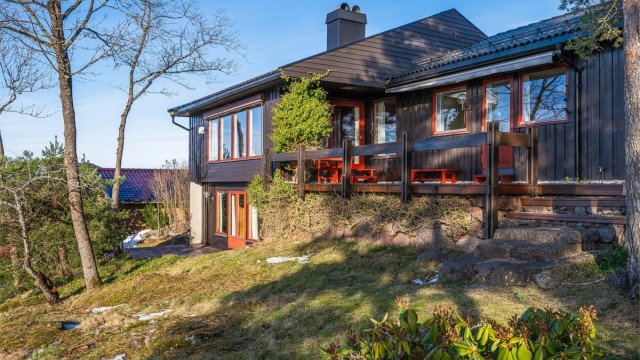 Velholdt bolig med store vindusflater og naturlig tilknytning til tomt og terreng.