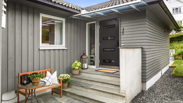 Inngangsparti med glassoverbygg, skifertrinn og markterrasse.