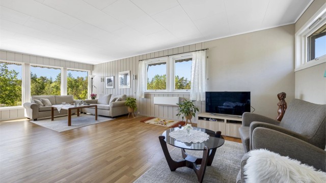 Stuen har en takhøyde på 2,37 meter og veggflater med en kombinasjon av malt panel og tapet.