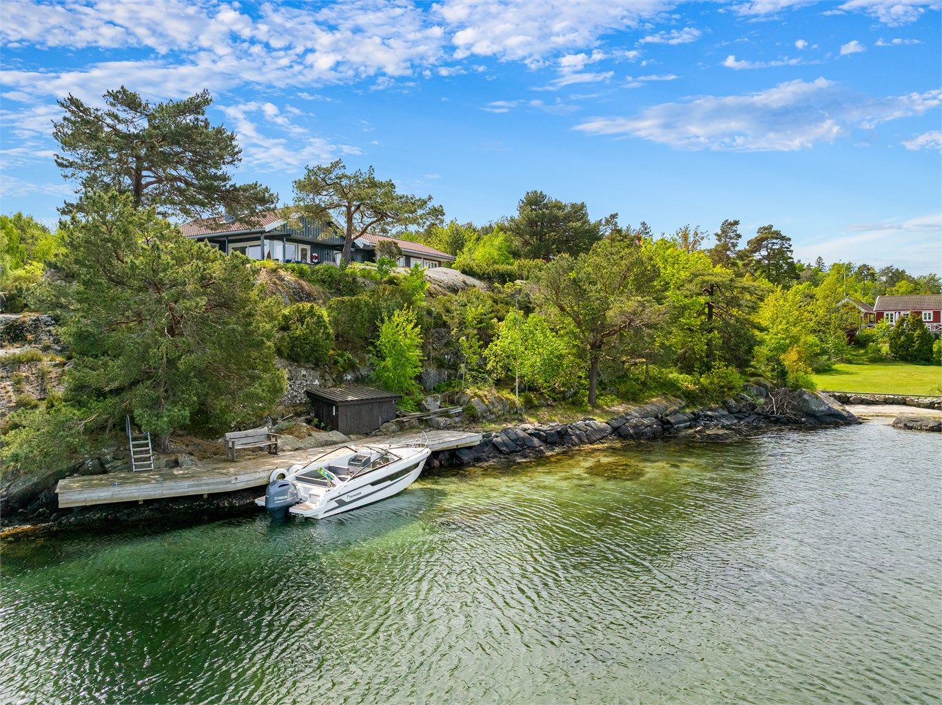 Langstrakt strandlinje med egen sti opp til eiendommen. 