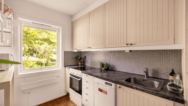 Vindu med hyggelig utsyn og plass til liten spiseplass foran kjøkkenvindu.