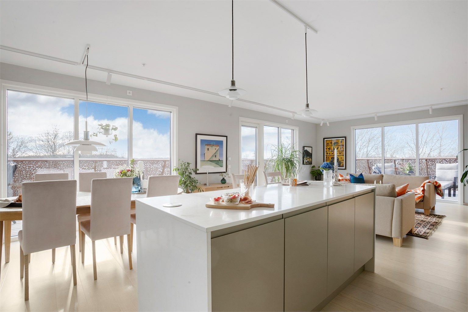 Kjøkken i åpen løsning . Store vinduer  gir mye naturlig lys.