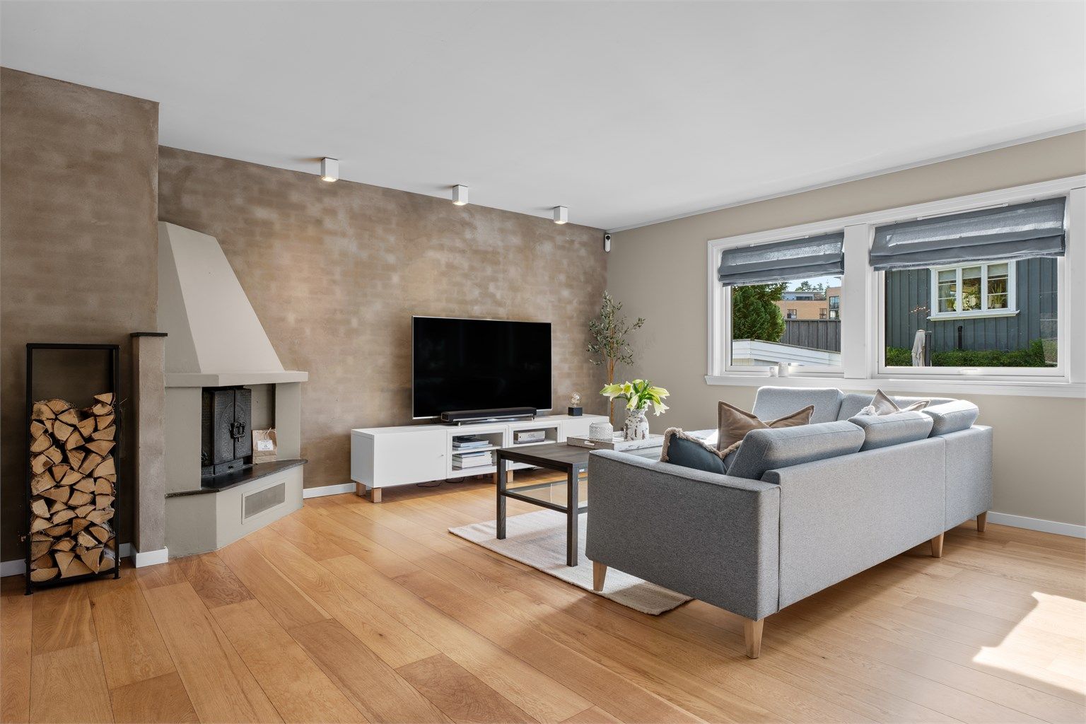 Stuen har god plass til sofagruppe, spiseplass og annet ønsket møblement, mens downlights i himlingen skaper en stilren atmosfære.