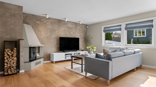 Stuen har god plass til sofagruppe, spiseplass og annet ønsket møblement, mens downlights i himlingen skaper en stilren atmosfære.