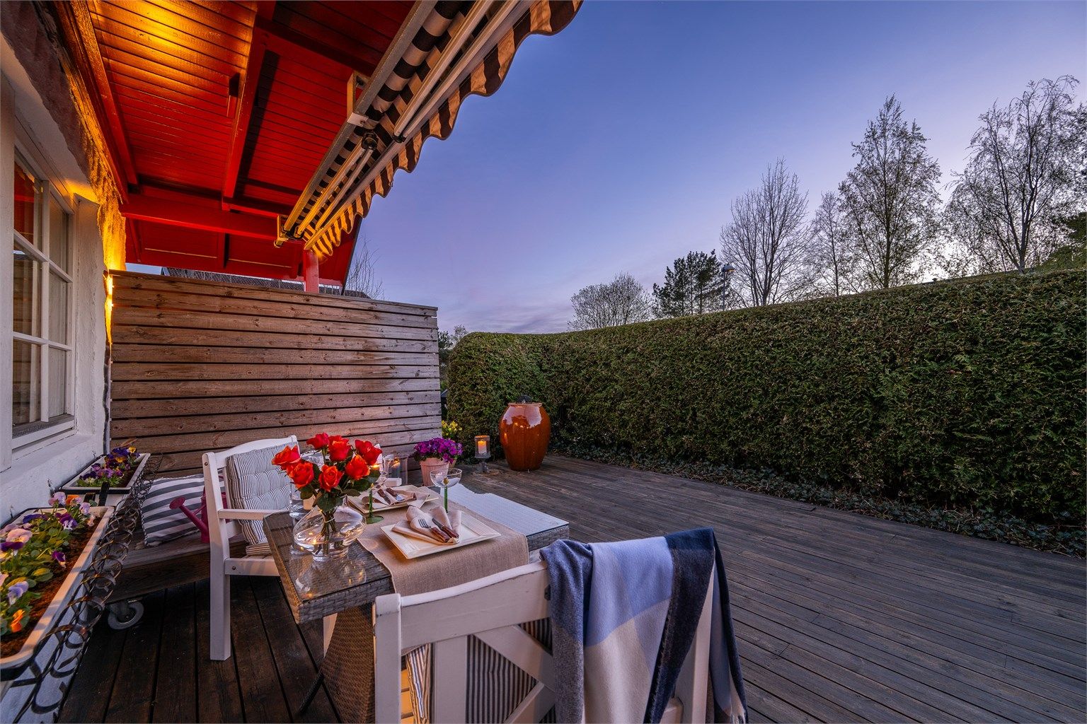 Uteplassen er rammet inn av en tett hekk som gir minimalt med innsyn.