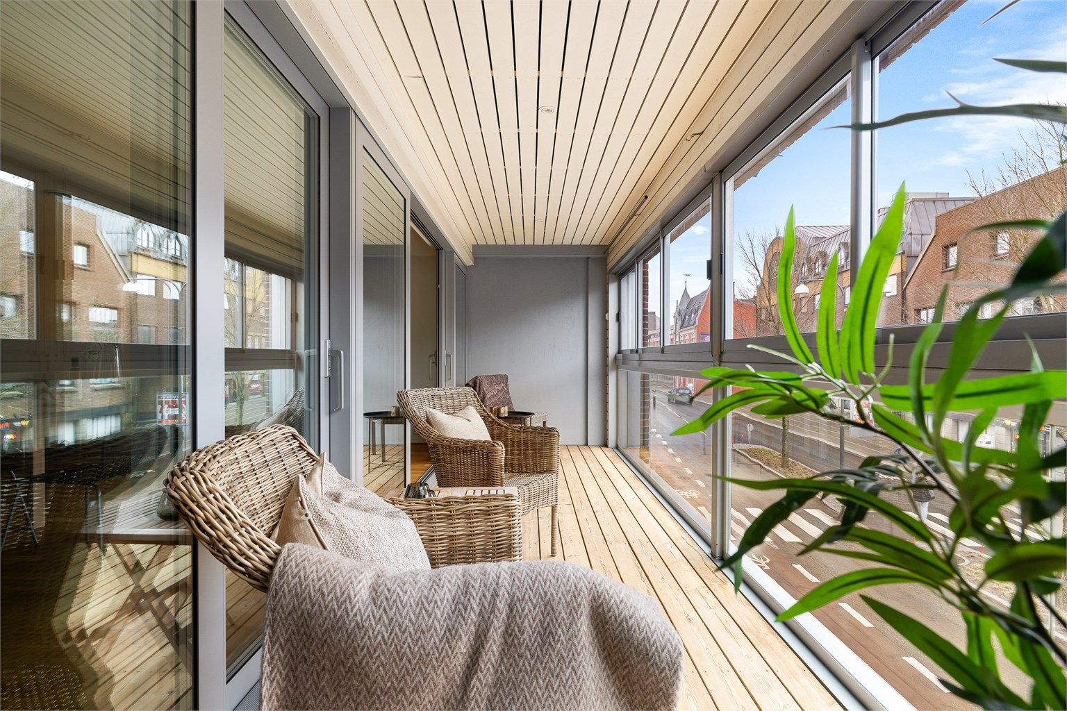 Verandaens gulv og himling er utført med lyst trepanel fremfor kald betong. Innfelte spotter besørger effektfull belysning.