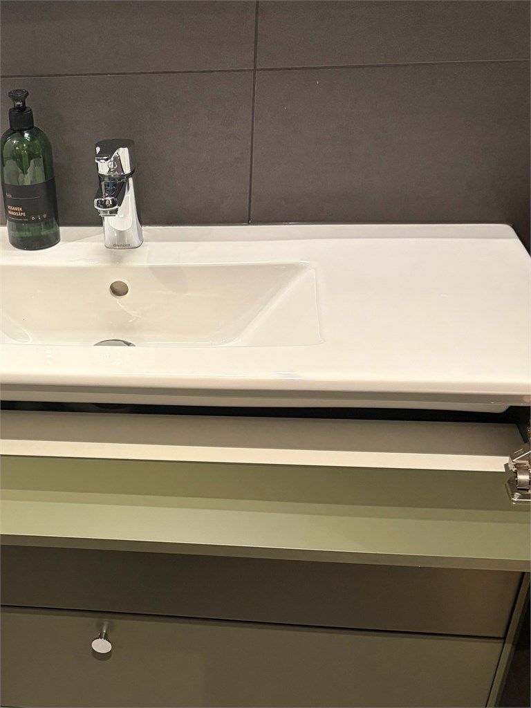 Innredningsdetalj bad - Begge bad i leiligheten har innredning med skjult rom for oppbevaring bak blindfelt under servant. 