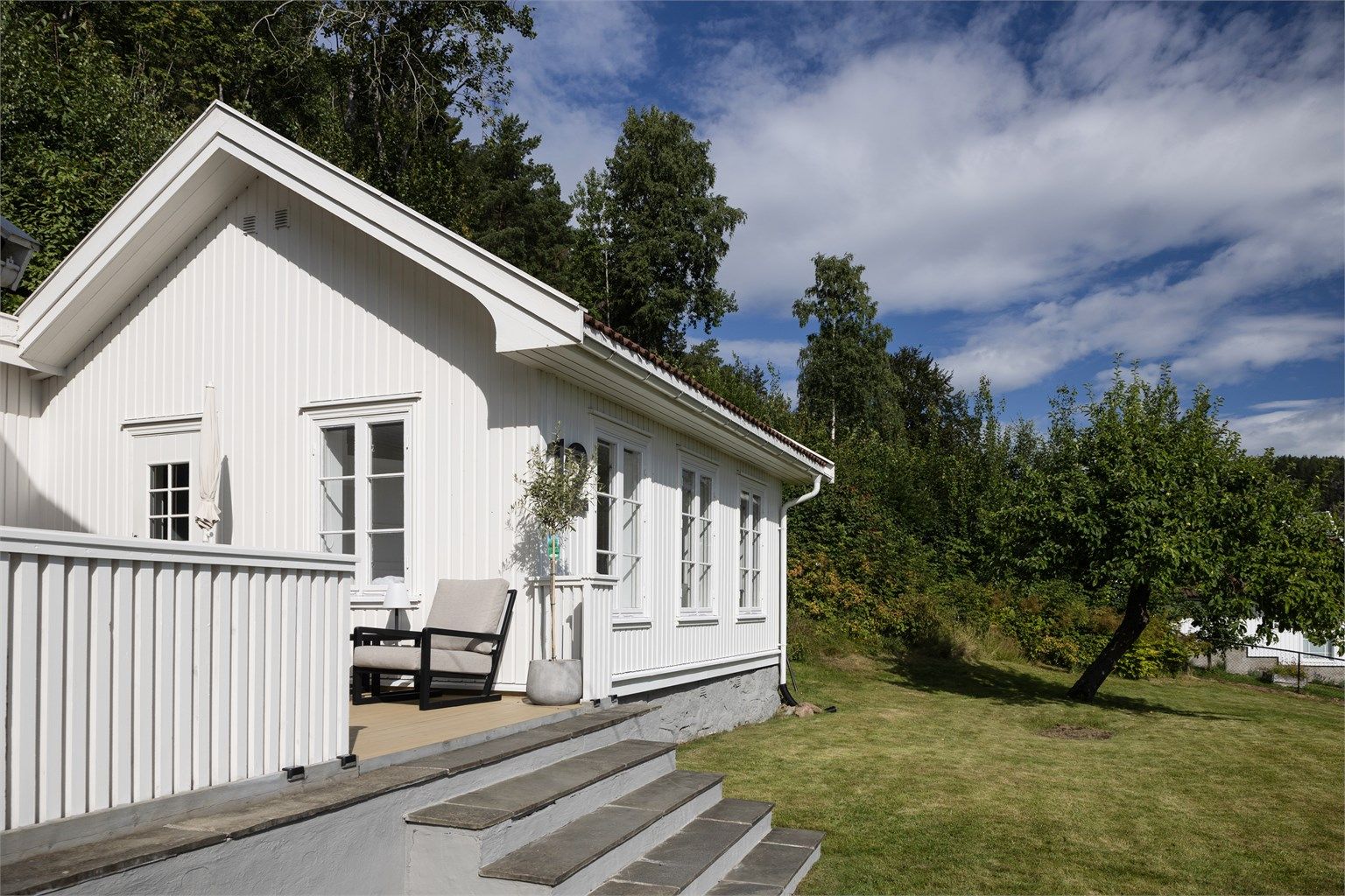 Eiendommen har en stor hage og grenser mot skogsområder i bakkant.