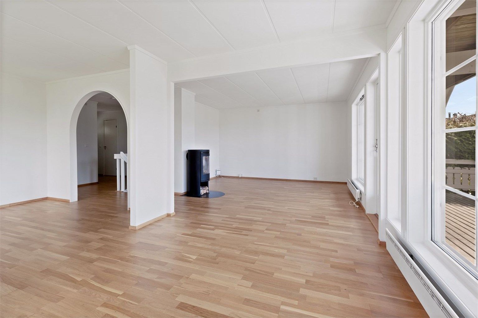 Lys og romslig stue med utgang til terrasse og hage.