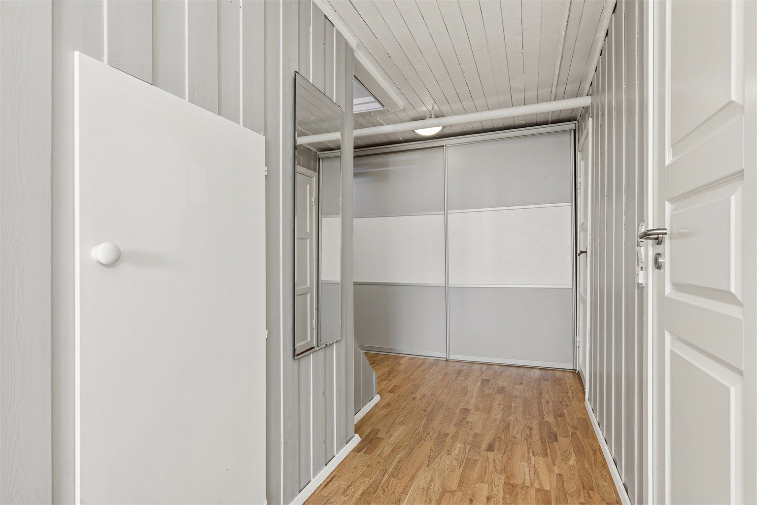 Gang i kjeller har fin lagringsplass i skyvedørsgarderobe og eget bodrom