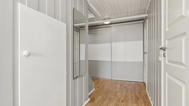 Gang i kjeller har fin lagringsplass i skyvedørsgarderobe og eget bodrom