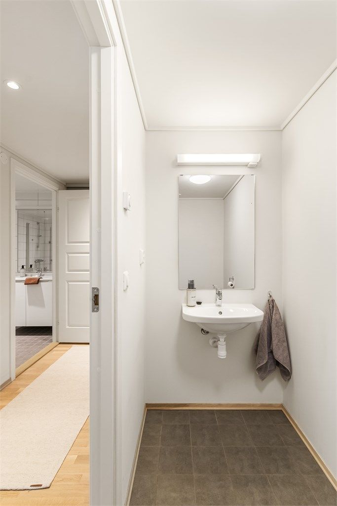 Leiligheten har et praktisk, separat gjestetoalett med flislagt gulv med gulvvarme.