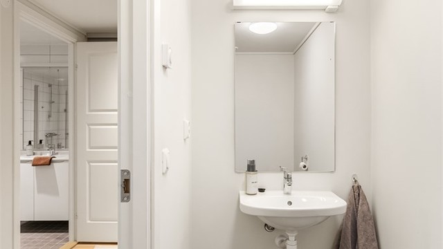 Leiligheten har et praktisk, separat gjestetoalett med flislagt gulv med gulvvarme.