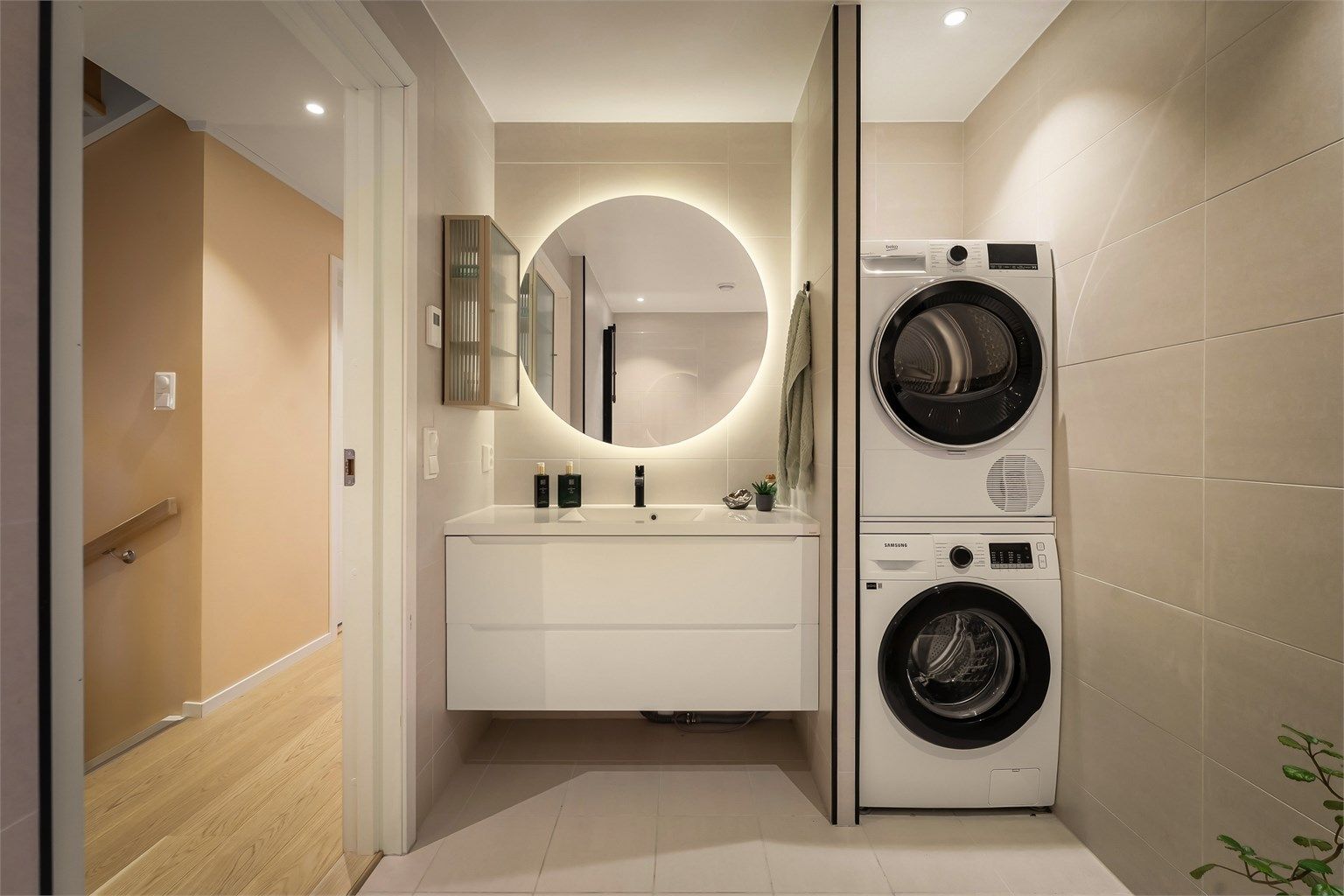 Lekkert flislagt baderom med opplegg for vaskemaskin/tørketrommel