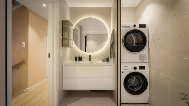 Lekkert flislagt baderom med opplegg for vaskemaskin/tørketrommel