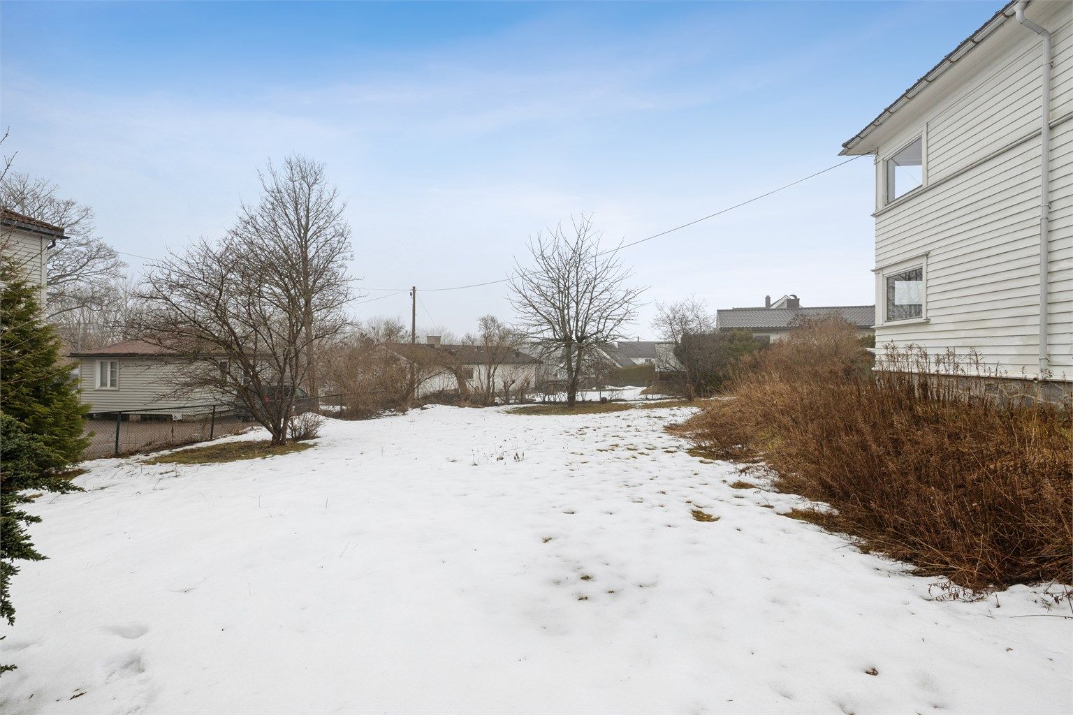 Hagen er opparbeidet med gressplen, trær og diverse beplantning.