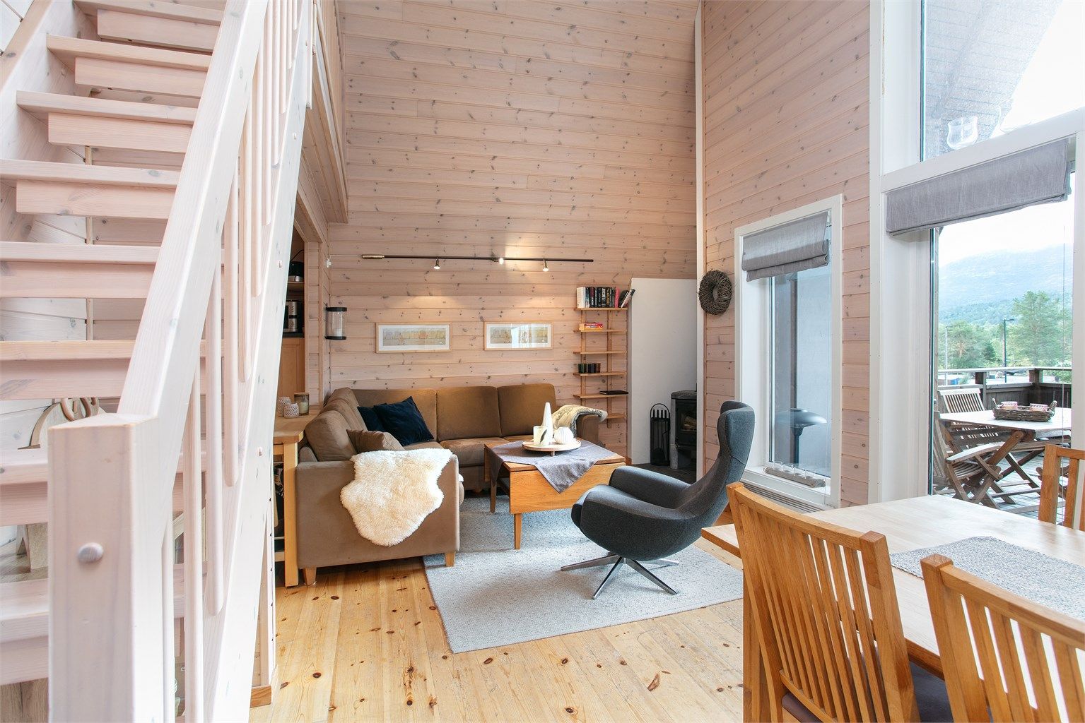 Stuen preges av store vindusflater og åpen trappeadkomst opp til hemsen.
