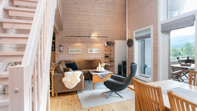 Stuen preges av store vindusflater og åpen trappeadkomst opp til hemsen.