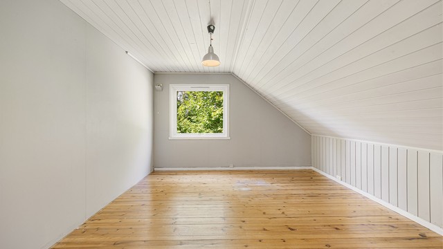 Rommene i loftsetasjen har skråtak og malte flater.
