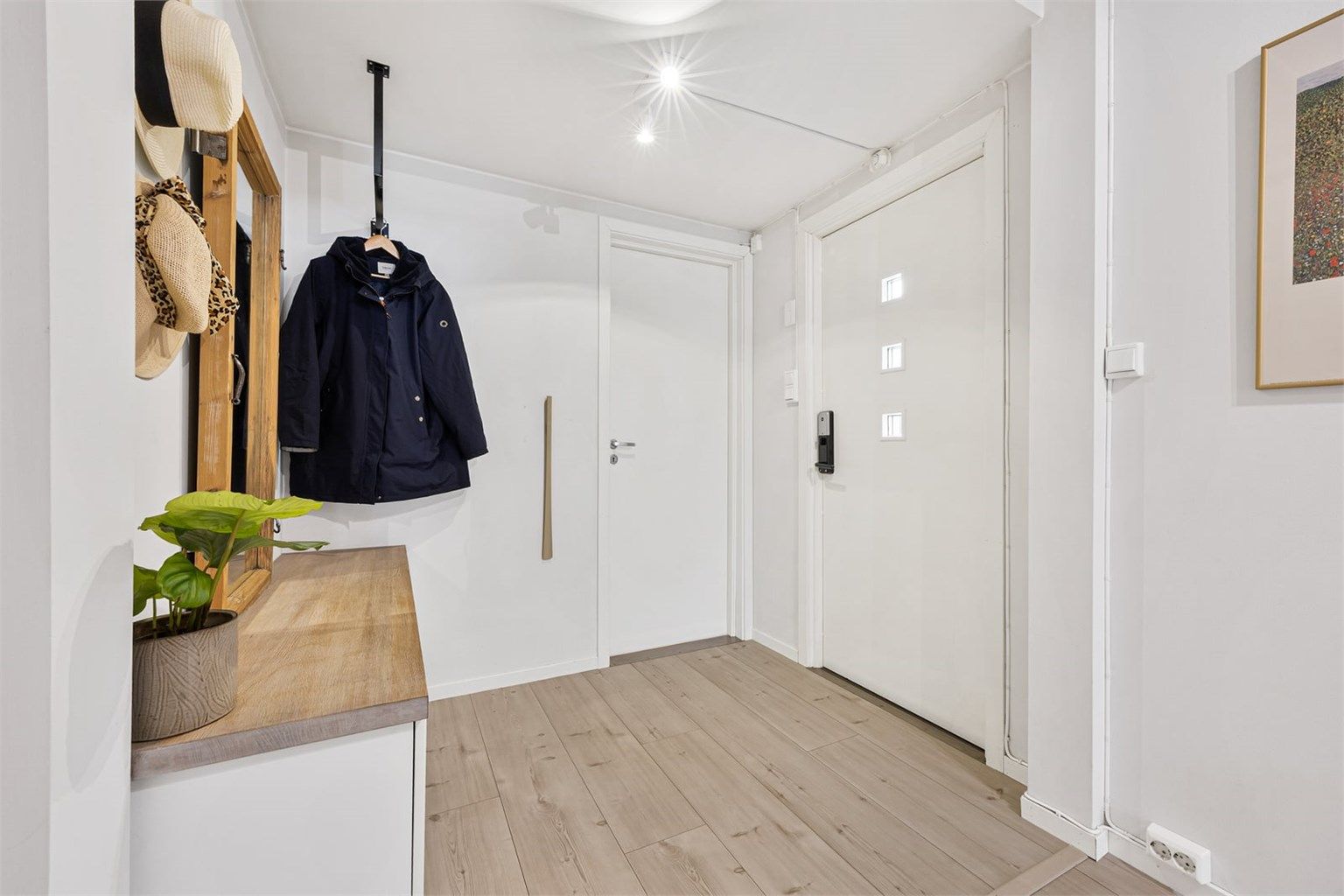 Velkommen inn i en lys entré med plass til oppbevaring av yttertøy.