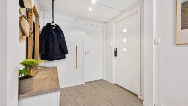 Velkommen inn i en lys entré med plass til oppbevaring av yttertøy.