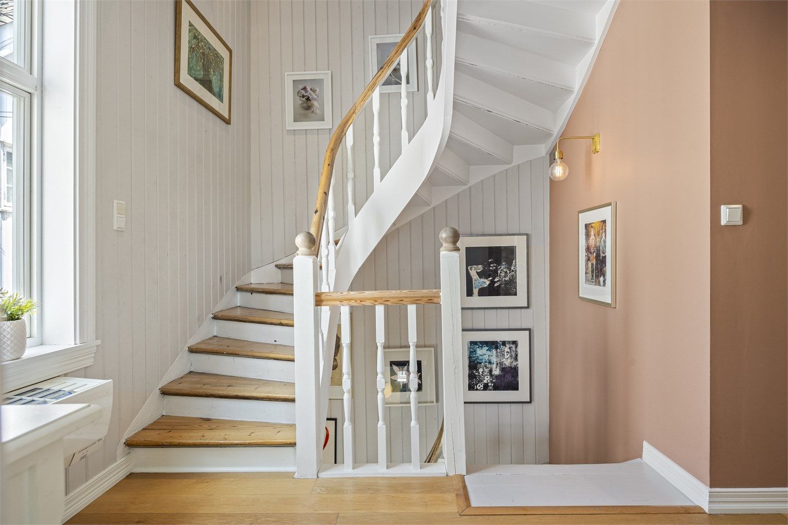 Den svingete tretrappen binder etasjene sammen og er et sjarmerende element i boligen.